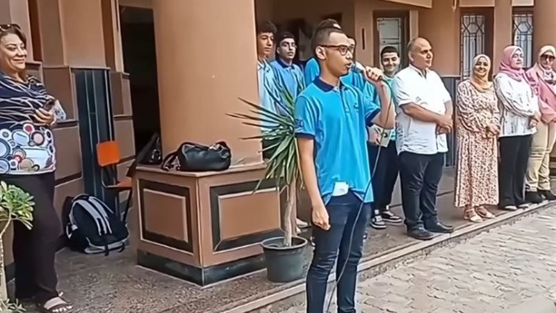 الطالب أثناء تأديته النشيد الوطنى باللغة الأنجليزية