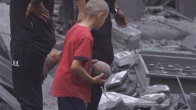 طفل فلسطيني يبحث عن أغراضه بين أنقاض منزله المدمر