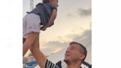 صحفي فلسطيني يحاول تهوين الأوضاع على طفلة في مخيم