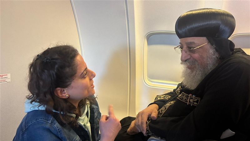 البابا تواضروس مع أحد شابات على متن الطائرة 