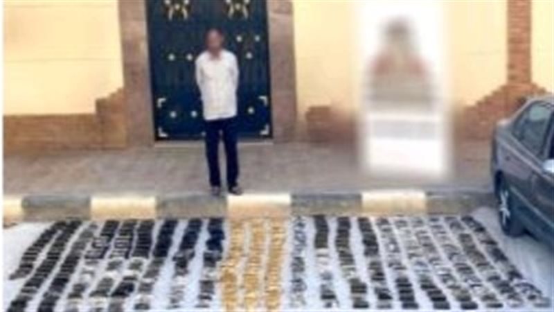 احد العناصر الإجرامية وامامه جانب من المضبوطات 