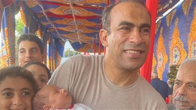 سيد عبد الحفيظ يحمل رضيعا أثناء انتخابات النادي الأهلي