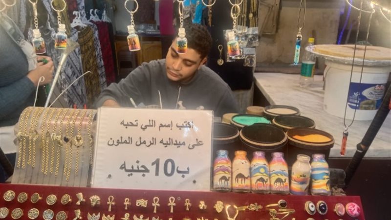 شاب يرسم على الرمل في الحسين