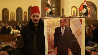 بالطربوش الأحمر وصورة الرئيس السيسى.. عمدة أسيوط يحتفل بعيد الميلاد المجيد