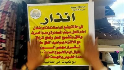 لافتات تحذيرية لأصحاب المحال التجارية بشارع العريش من التعدى على الطريق