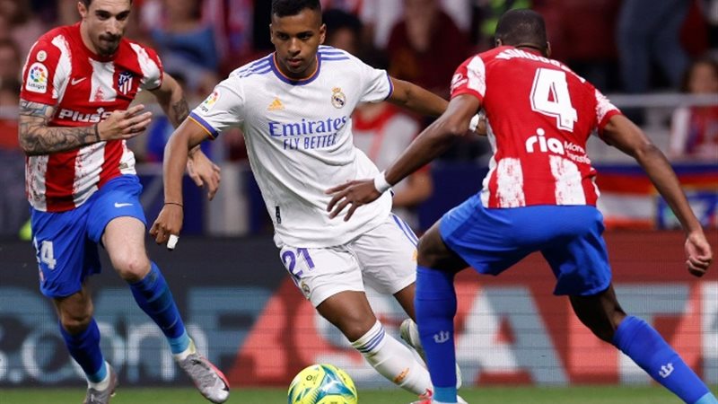 لاعب ريال مدريد يراوغ دفاع أتليتكو مدريد